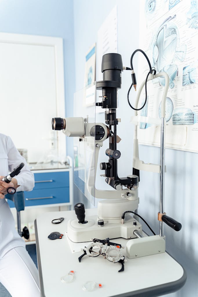 Close-up of a slit lamp microscope in a modern optometry clinic setup.